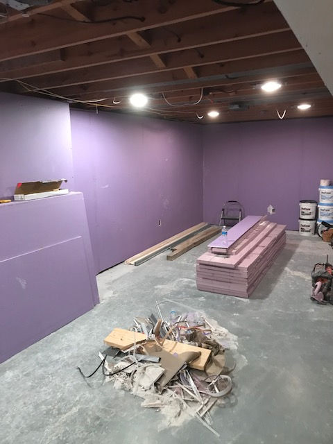 A room with purple walls and a pile of wood on the floor