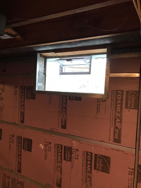 A room with a window and foam insulation on the wall