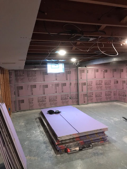 A room with a lot of purple sheets of styrofoam on the floor.