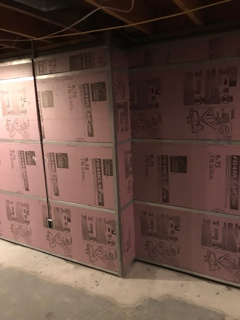 A wall of pink styrofoam in a basement.