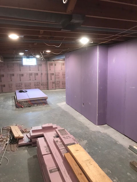 A basement with purple walls and wooden boards.