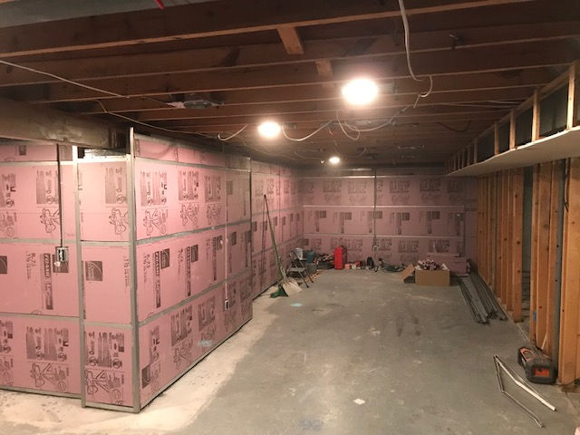 A basement with a lot of insulation on the walls and ceiling.