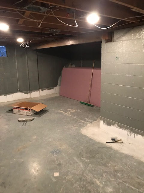 An empty basement with a box on the floor.