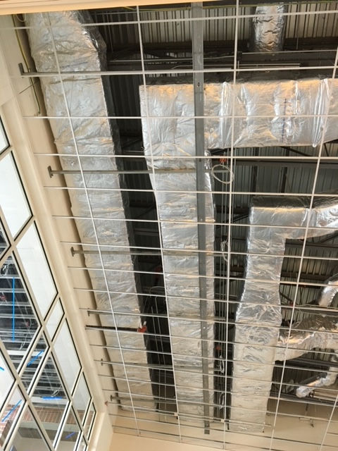 A ceiling with a lot of pipes hanging from it.