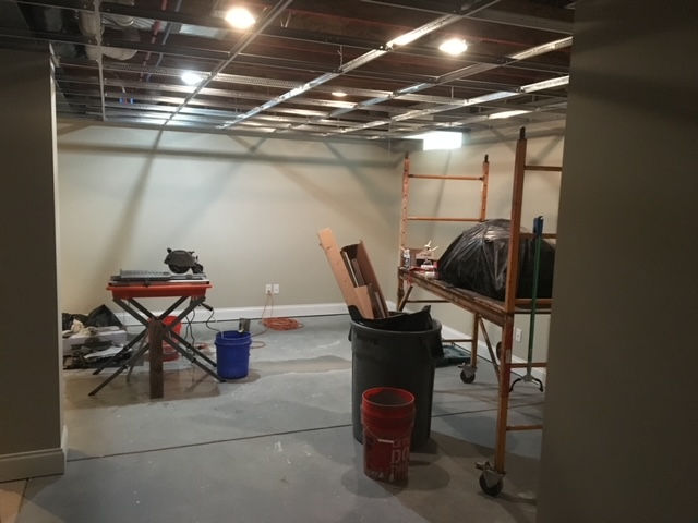 A room with a scaffolding and trash cans in it