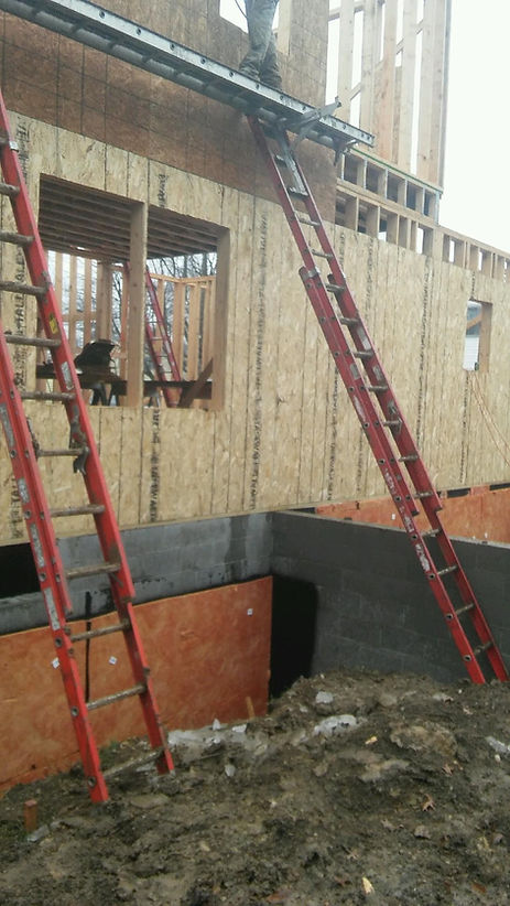 A ladder is leaning against a building under construction.
