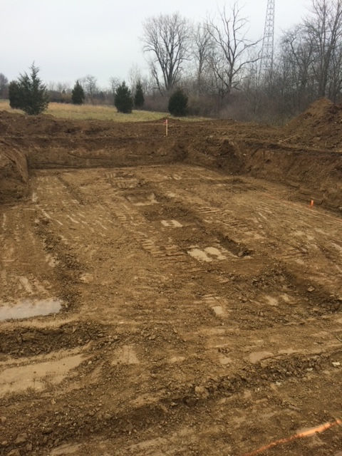 A large pile of dirt is sitting in the middle of a field.