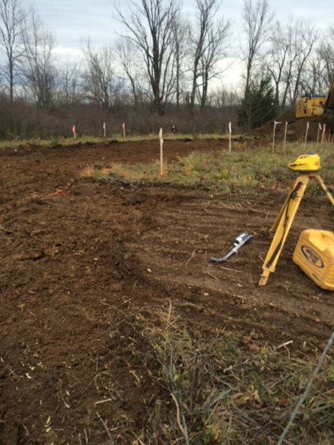 A yellow tripod is sitting in the middle of a dirt field.