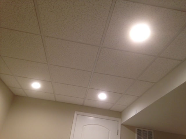 A room with a tiled ceiling and a door.