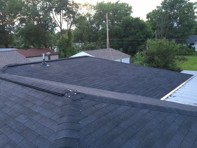 The roof of a house with a black shingle roof