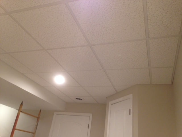 A room with a tiled ceiling and a door