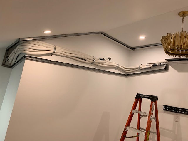 A room with a ladder and a chandelier on the ceiling