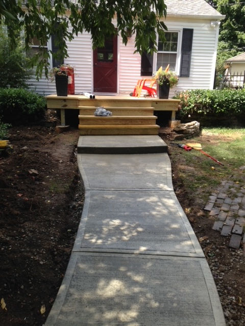 A concrete walkway leading to a white house