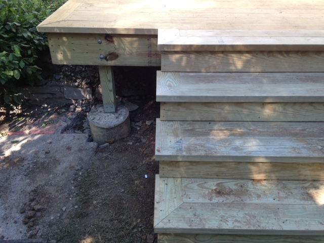A stack of wooden steps leading up to a wooden deck