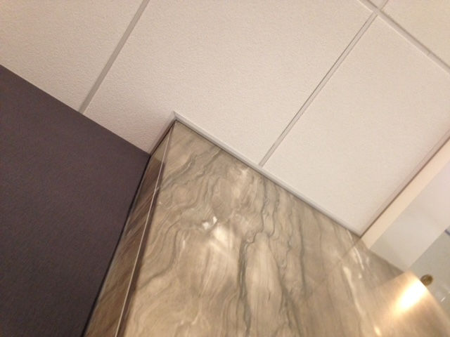 A room with a marble wall and a white ceiling