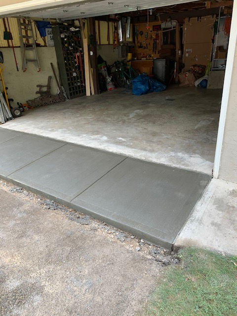 A concrete walkway is being built into a garage.