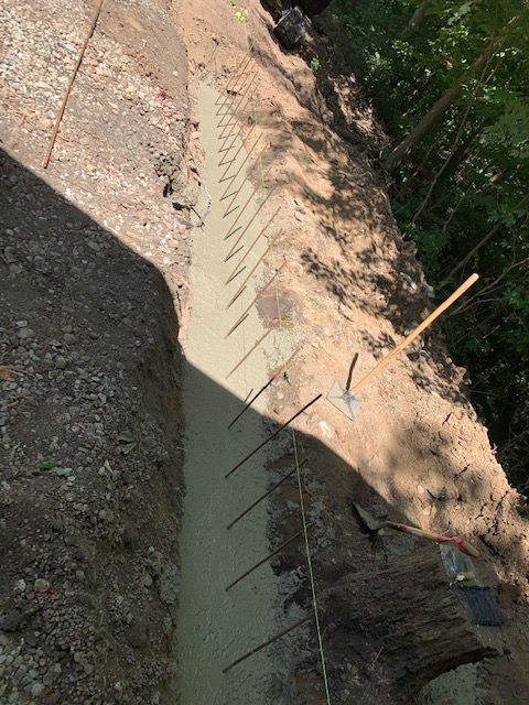 A concrete wall is being built in the woods