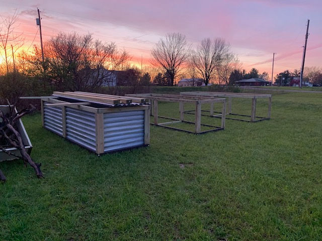 A bunch of wooden boxes are sitting on top of a lush green field.