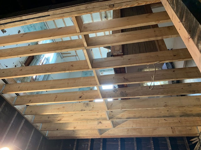 The ceiling of a building is being built with wooden beams