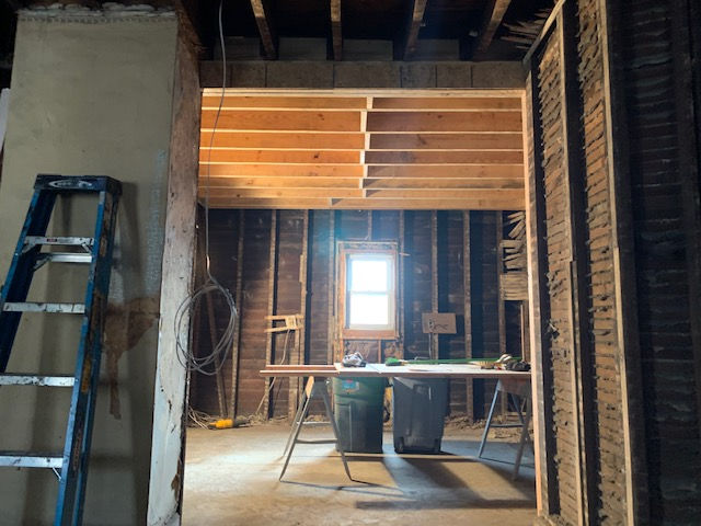 A room with a ladder and a table in it