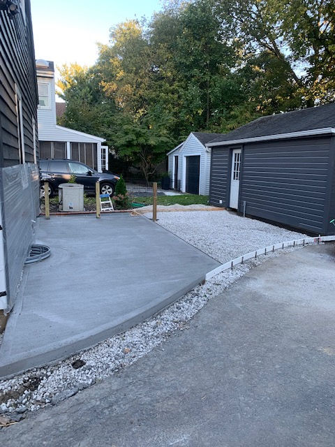 A concrete driveway leading to a garage and a house.