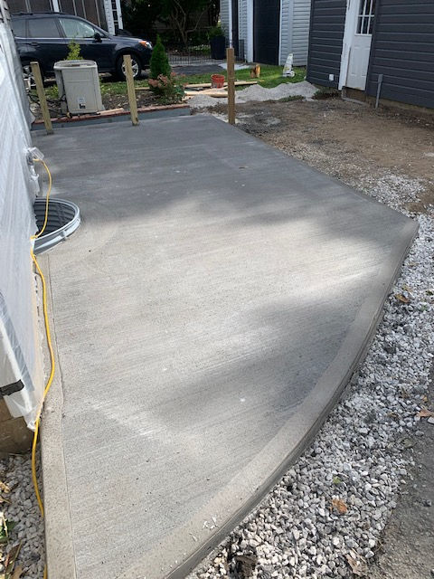 A concrete walkway is being built in front of a house.