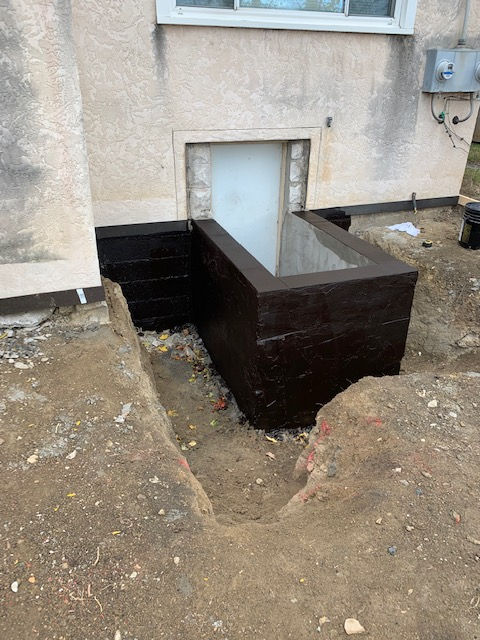 There is a hole in the ground in front of a building.