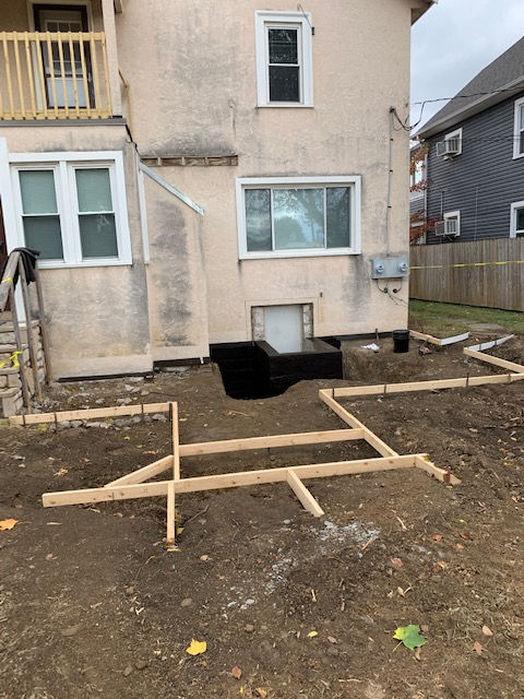 A house with a hole in the ground in front of it