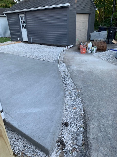 A concrete driveway is being built in front of a garage.