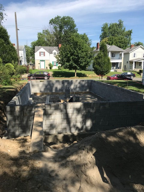 A concrete foundation is being built in a residential neighborhood