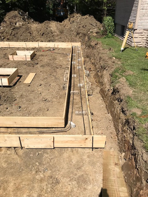 A wooden foundation is being built in the dirt.