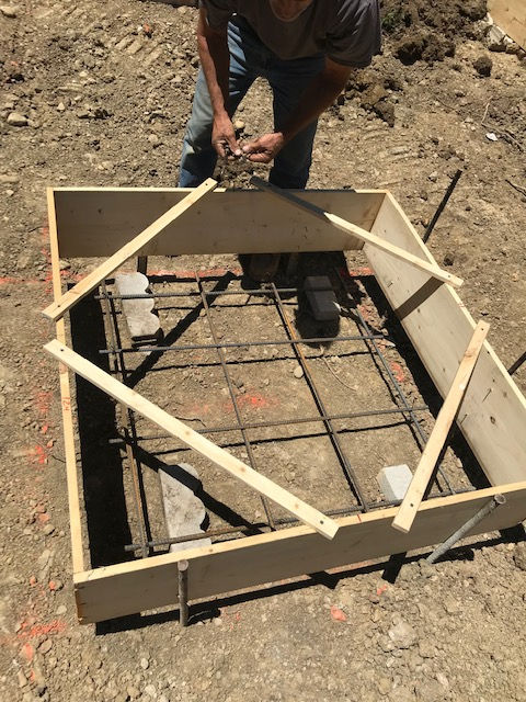 A man is standing next to a wooden box on the ground