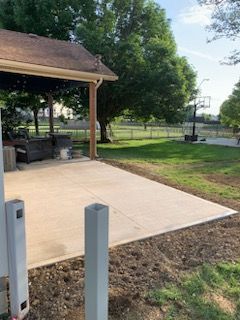 A patio with a basketball hoop in the backyard of a house.