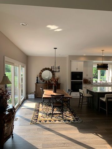 A dining room with a table and chairs and a rug.