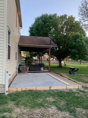 A patio is being built in the backyard of a house.