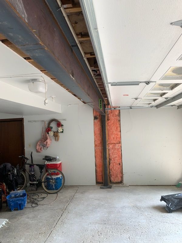 A garage with a large metal beam hanging from the ceiling.