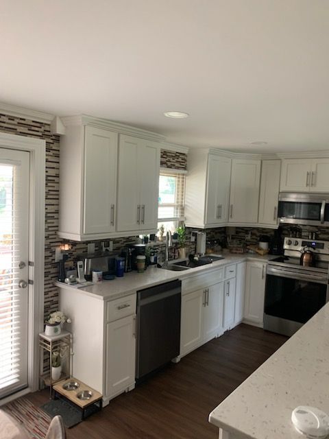 A kitchen with white cabinets and stainless steel appliances