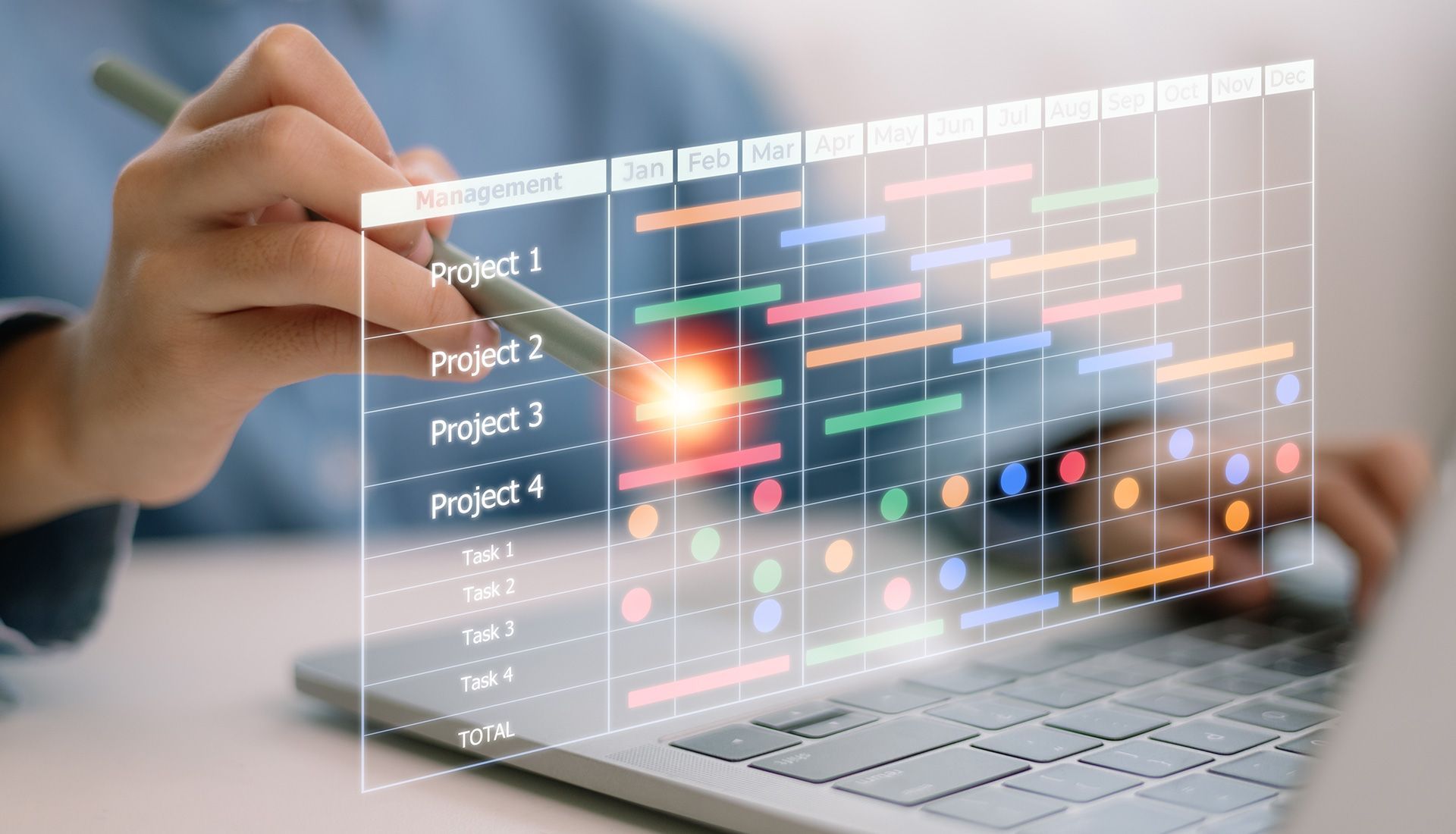 Person pointing at a digital project schedule on a laptop screen with colorful task bars and calendar grid.