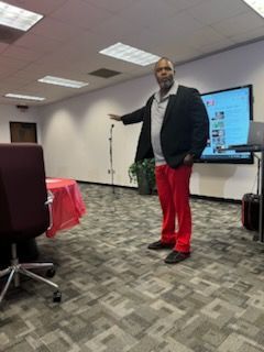 Man in suit presenting financial data to a group in a conference room.