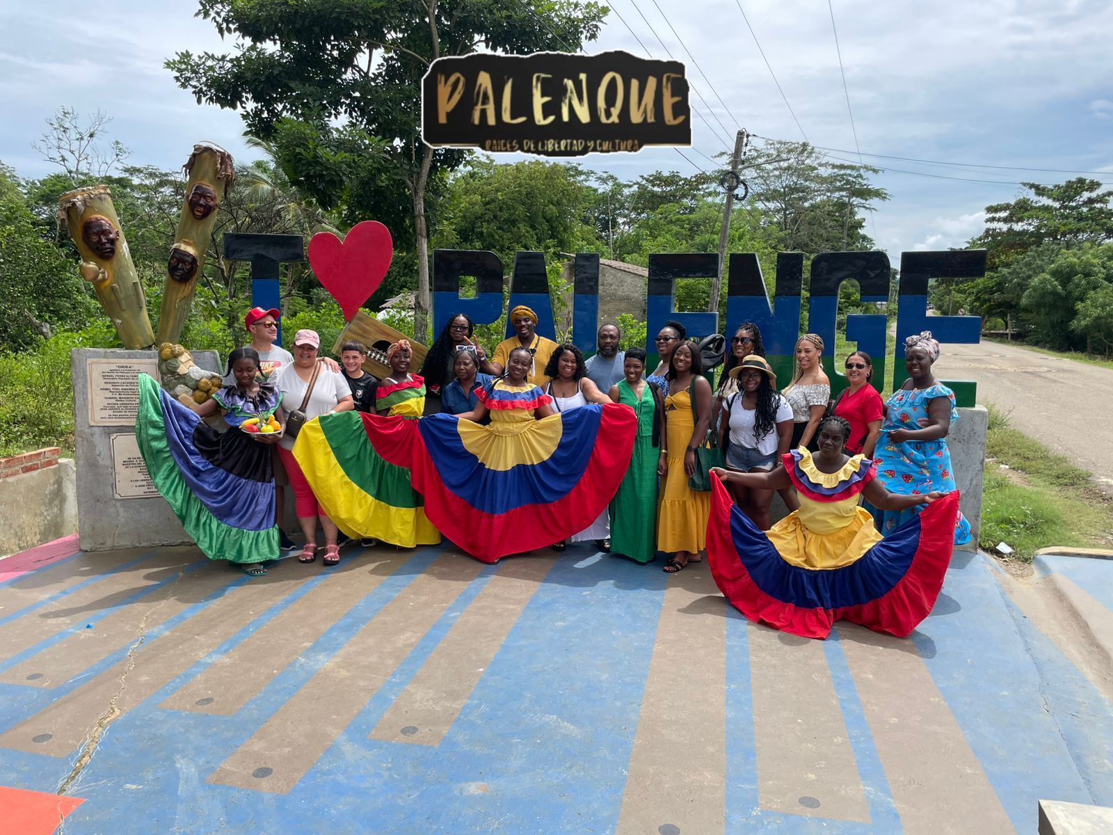 Un grupo posa junto al cartel