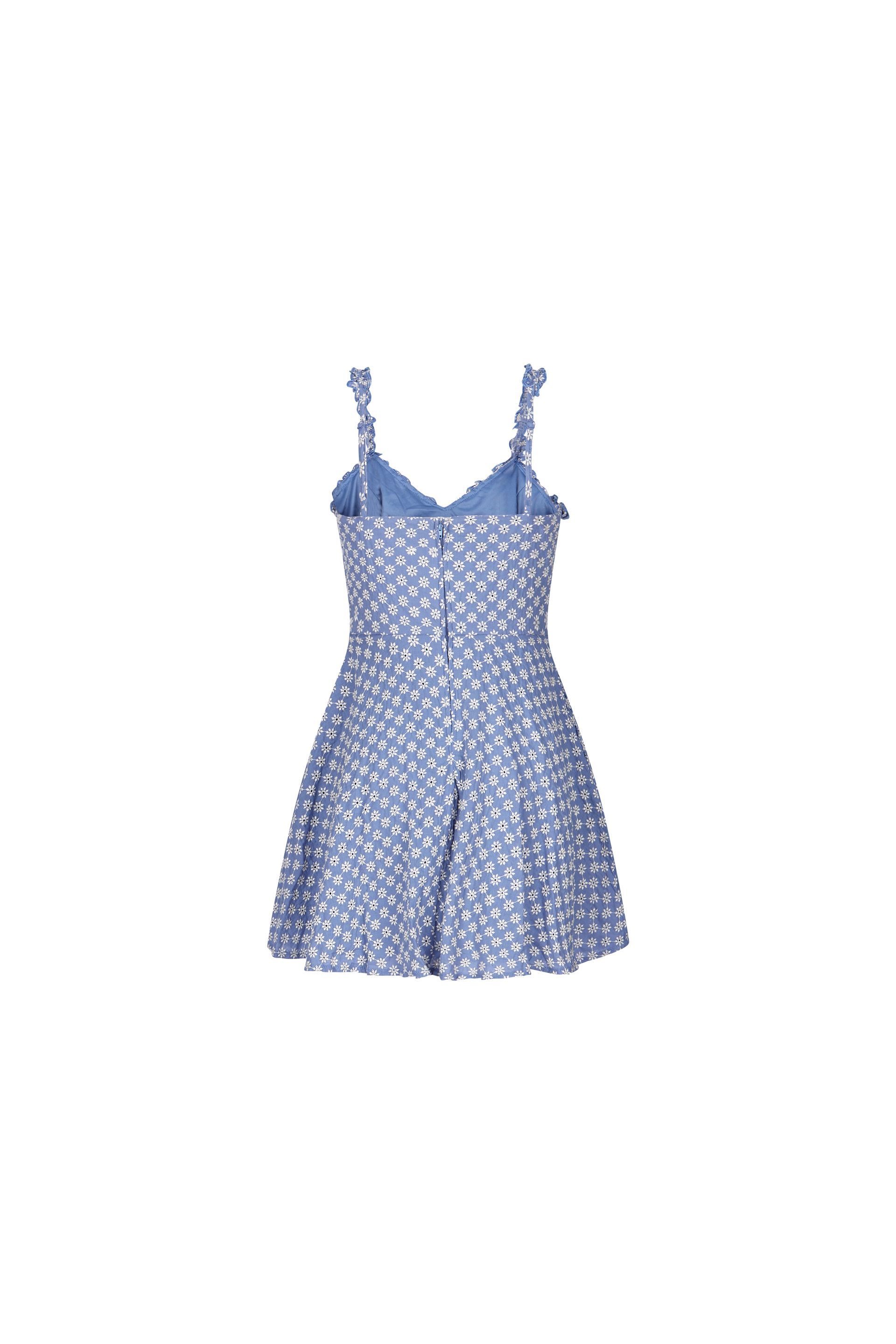The back of a blue and white polka dot dress on a white background.