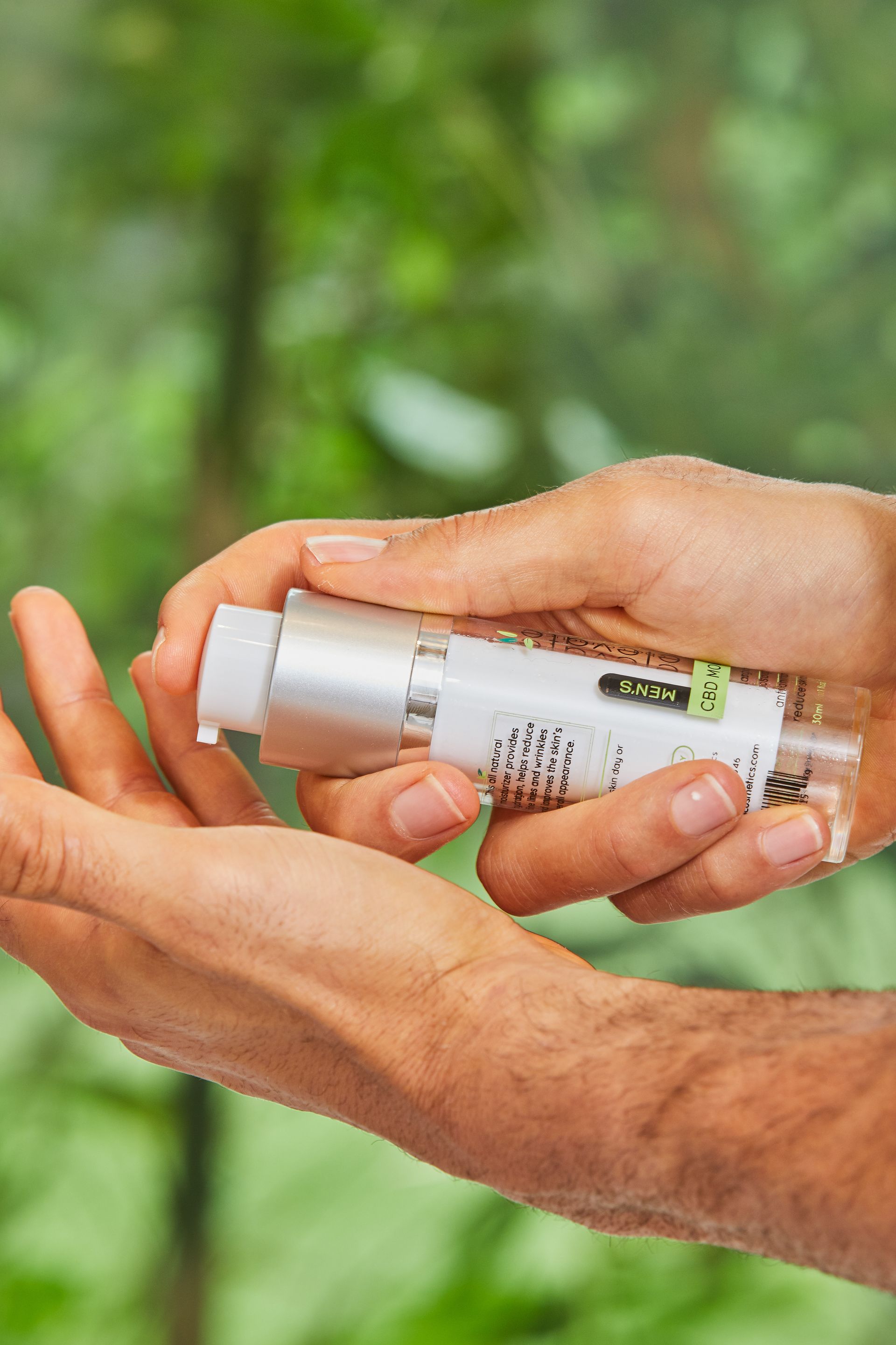 A person is holding a bottle of lotion in their hand.