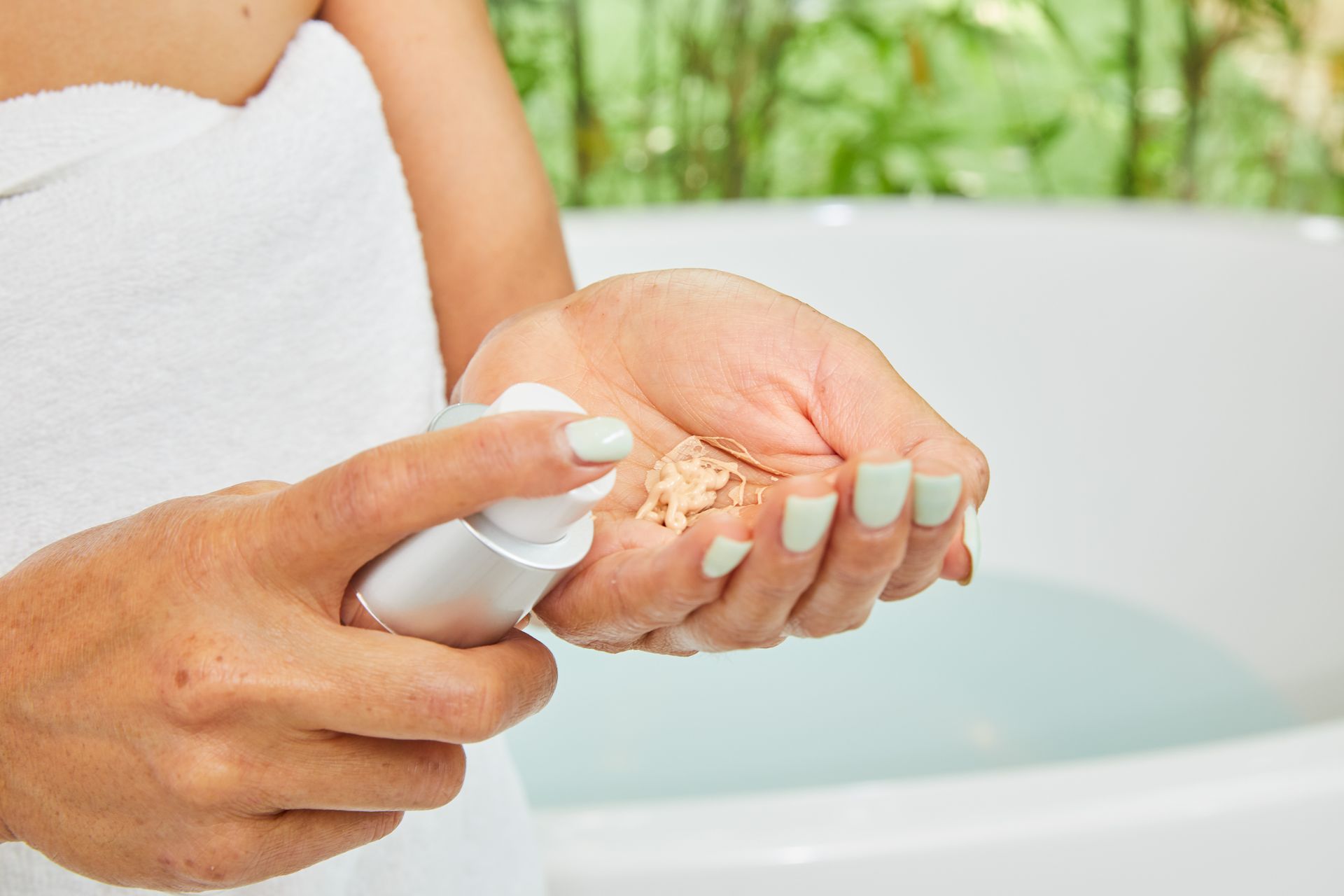 A woman is holding a bottle of lotion in her hands.