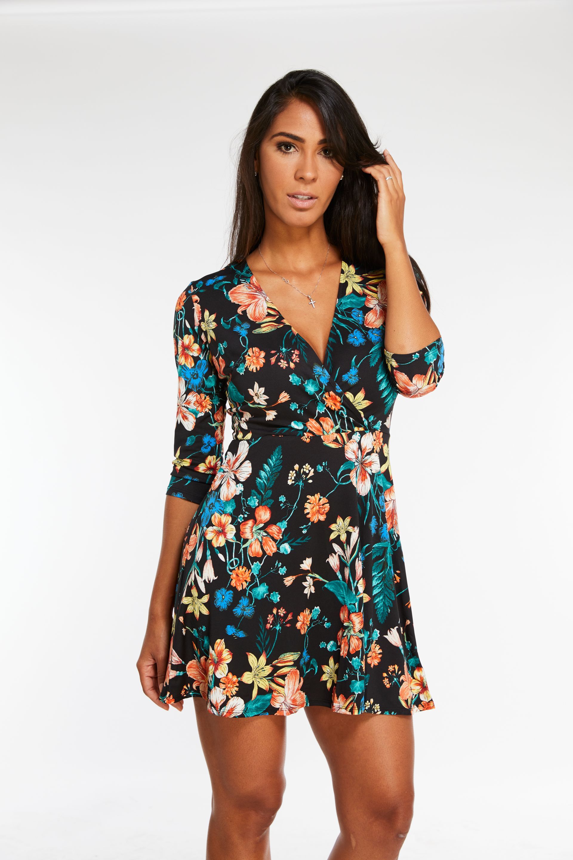 A woman is wearing a black floral dress with a v-neck.
