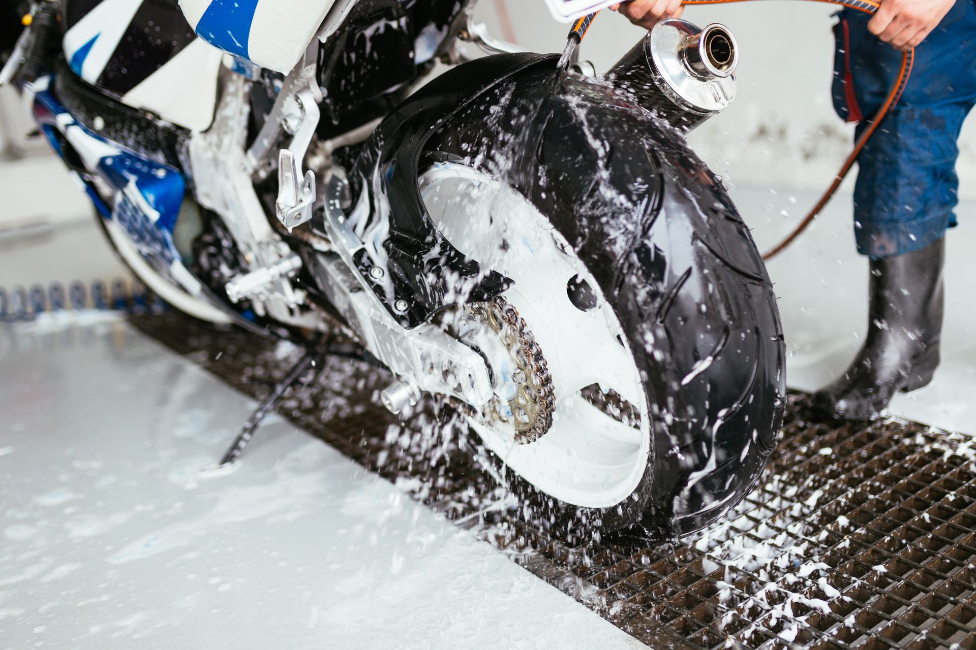 a person is washing a motorcycle with soap and water .