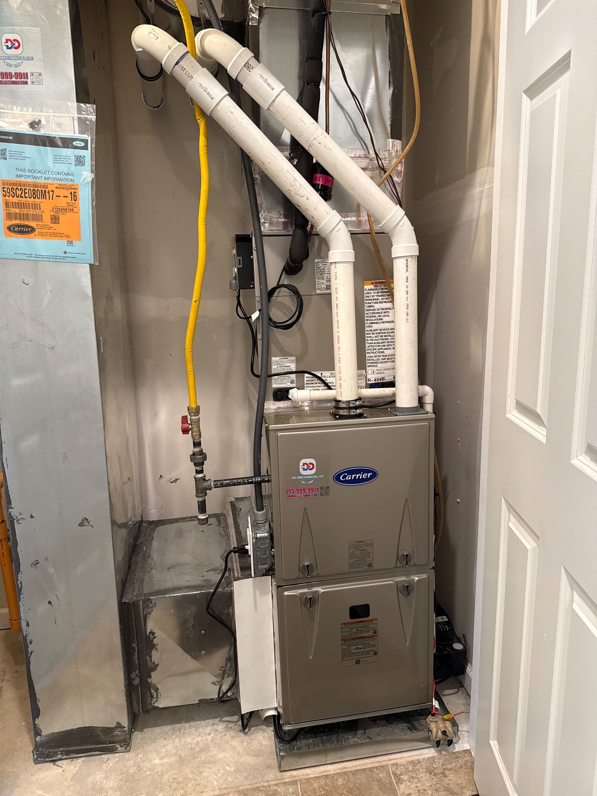 Furnace and ventilation system in a utility closet with white PVC pipes, a yellow gas line, and a gray metal cabinet.
