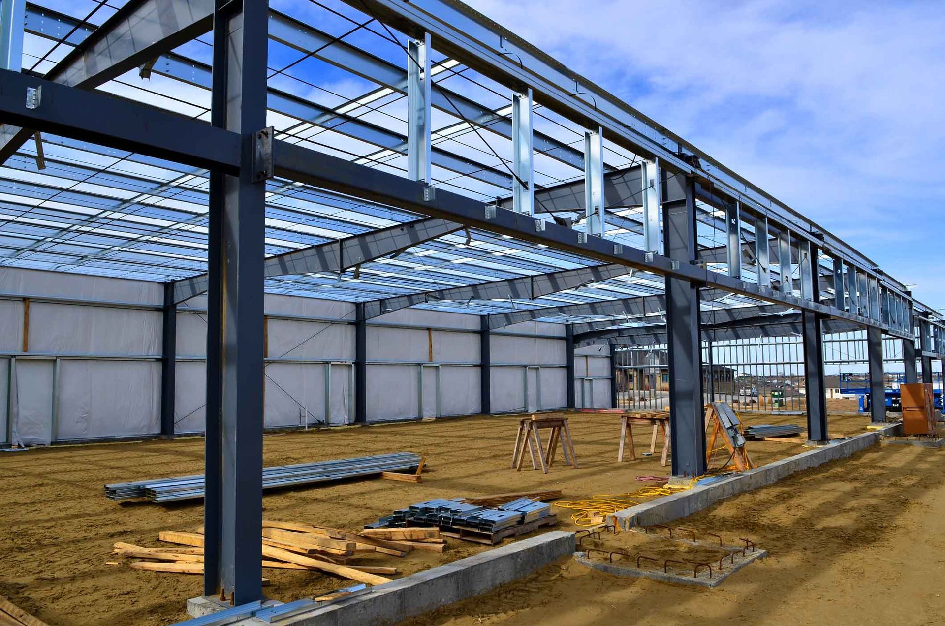Steel frame construction of a large building on a sunny day.