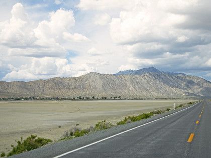 A road in the desert with mountains in the background