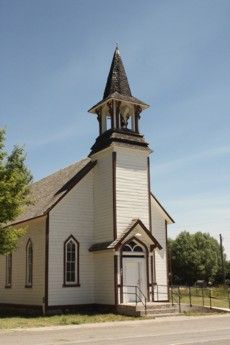 A small white church with a bell tower on top of it