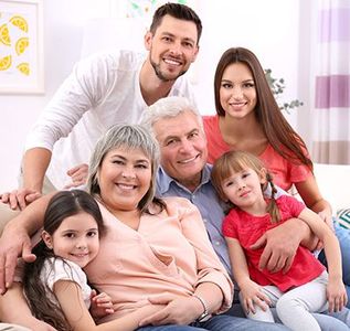 A family is posing for a picture while sitting on a couch.